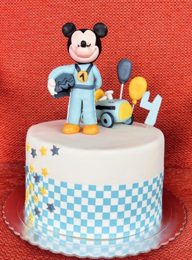 TARTA MICKEY Pastel decorado con Mickey Mouse y temática de carrera, con globos y estrellas.