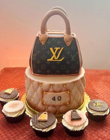 TARTA BOLSO EN 3D Tarta grande en forma de bolso de diseñador con cupcakes decorados a su alrededor.